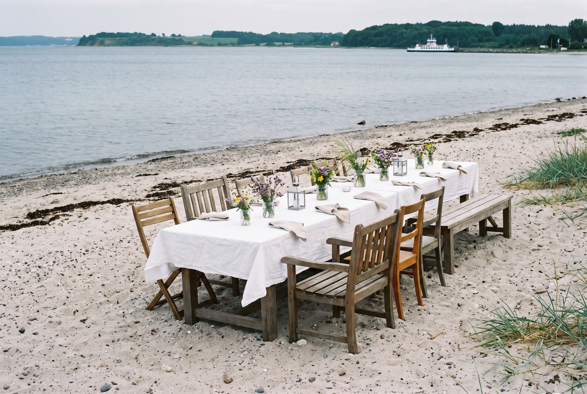 Hochzeitslocation in Kiel: Hochzeitstafel am Strand in Kiel-Falckenstein mit Blick auf die Förde